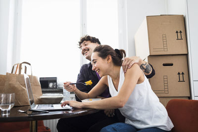 Couple eating lunch and using laptop