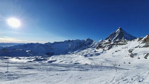 Scenic view of snowcapped mountains against clear blue sky