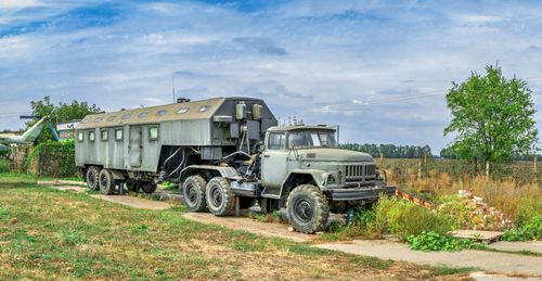 Abandoned truck on field against sky