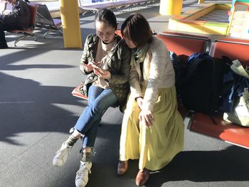 Women sitting on mobile phone in bus