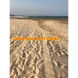 Text written on beach against sky