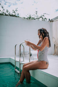 Woman sitting in swimming pool