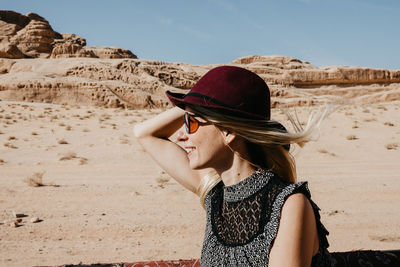 Smiling woman wearing hat at beach against sky