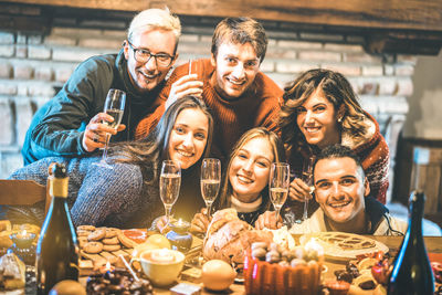 Portrait of smiling men and women holding drinks in glasses