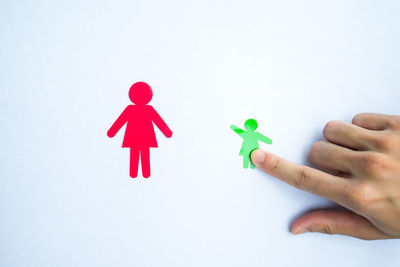 Midsection of person holding toy against white background