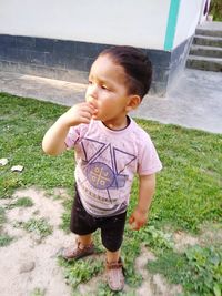 Cute boy looking away on field