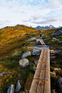 View of wooden hiking path and a hiking person in moskenesoya lofoten norway