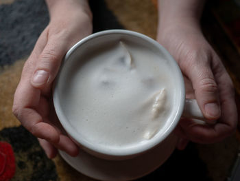 Cropped image of hand holding coffee cup