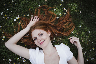 Portrait of smiling young woman with arms raised