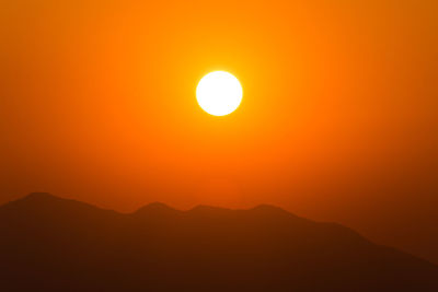 Scenic view of silhouette mountains against romantic sky at sunset