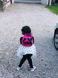 Rear view of girl standing on footpath