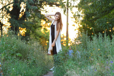 Woman standing on field in forest