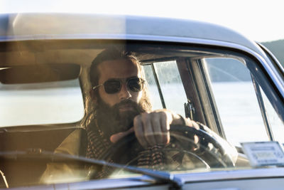 Handsome young man sitting in a car