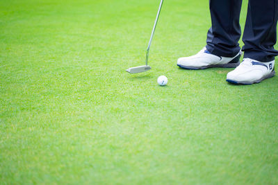 Low section of person playing golf on course