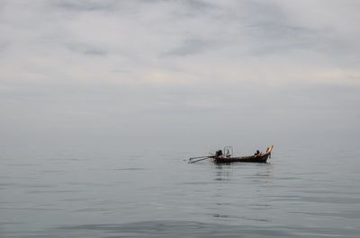 Fishing boat in sea against sky