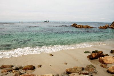 Scenic view of rocks at beach against sky