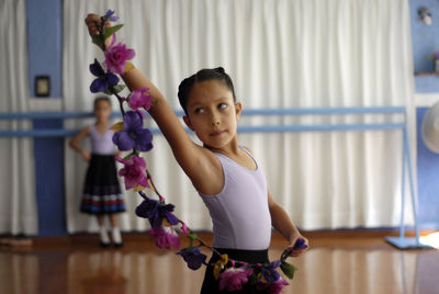 Portrait of girl standing against purple wall