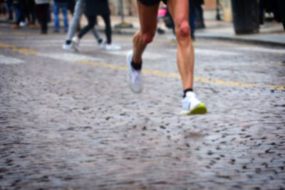 Low section of woman running on street