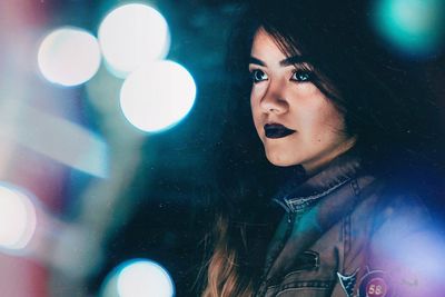 Close-up of thoughtful young woman looking away at night