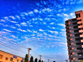 Low angle view of buildings against cloudy sky