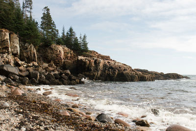 Scenic view of rocky beach against sky