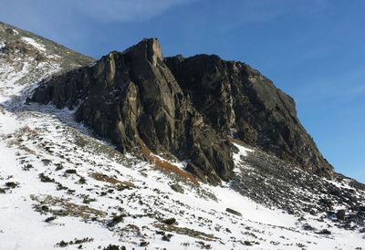Low angle view of snowcapped mountain against sky