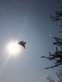 Low angle view of sun shining through clouds