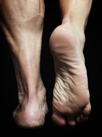 Close-up of human feet against black background