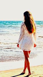 Rear view of woman standing on beach