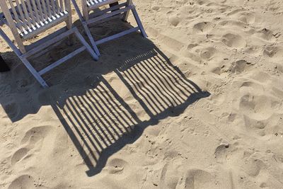 High angle view of chairs on sand at beach
