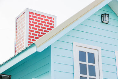 The roof of the blue house and red chimney