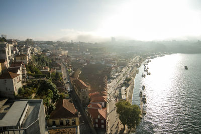 High angle view of townscape by sea against sky