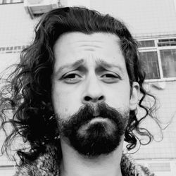 Close-up portrait of man with beard against building