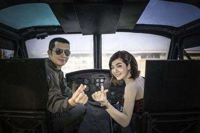 Portrait of couple gesturing while sitting in airplane