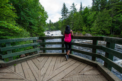 Rear view of woman standing at observation point over river