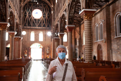 Senior woman praying at the historical cathedral of our lady of poverty of pereira, built in 1890