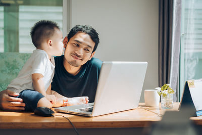 Father and son happy working at home