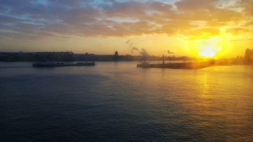 Scenic view of sea against dramatic sky during sunset