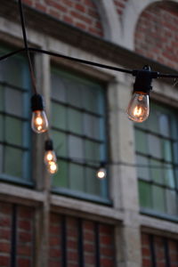 Low angle view of illuminated light bulb against building