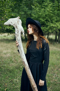 Side view of young woman standing on field