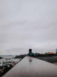 Rear view of man walking on road against sky