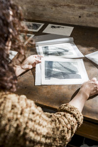 Female artist inspecting some pieces of hand made printings.