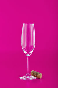 Close-up of wineglass against pink background