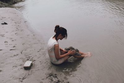 High angle view of woman sitting on beach