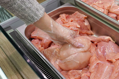 Meat in food store . woman choosing fresh chicken meat in supermarket