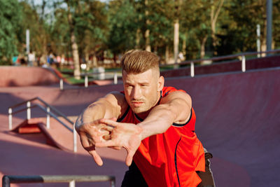 Portrait of young man using mobile phone while standing outdoors