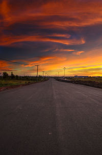 Country road against sky during sunset