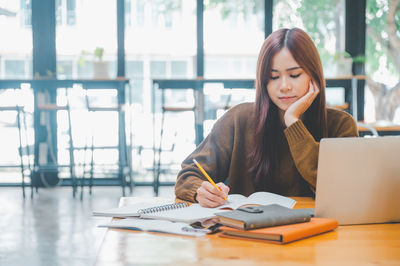 Portrait of young woman using digital tablet at office