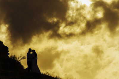 Low angle view of silhouette man standing against sky