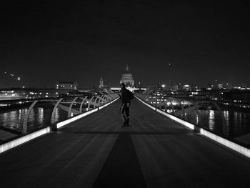 Man standing on bridge in city